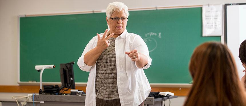 Faculty member teaching students sign language.