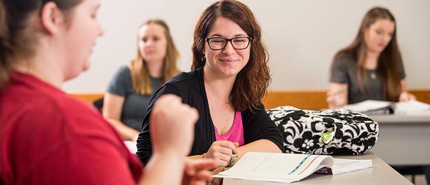 Faculty member teaching students sign language.